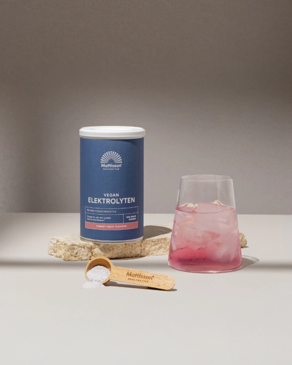 Mattisson Vegan electrolyten mockup met als synoniem Mattisson Elektrolytes mockup van het potje met schepje en een glas met de elektrolyten drank in de smaak bosvruchten oftewel forrest fruit