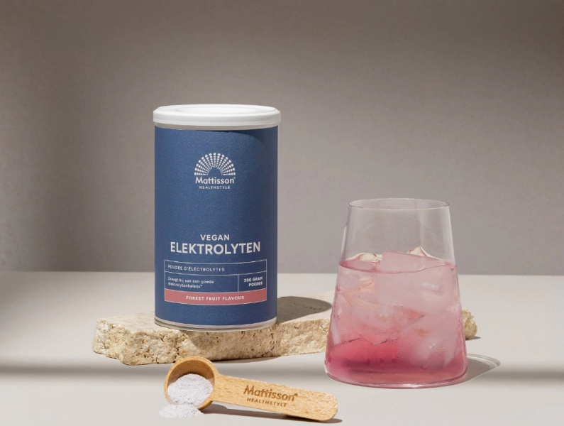 Mattisson Vegan electrolyten mockup met als synoniem Mattisson Elektrolytes mockup van het potje met schepje en een glas met de elektrolyten drank in de smaak bosvruchten oftewel forrest fruit